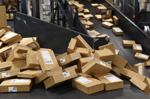 Netthandelspakker på rullebånd for sortering