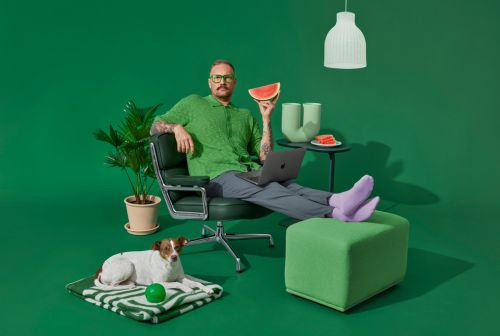 studiobilde mann sitter i stol med mac og vannmelon.